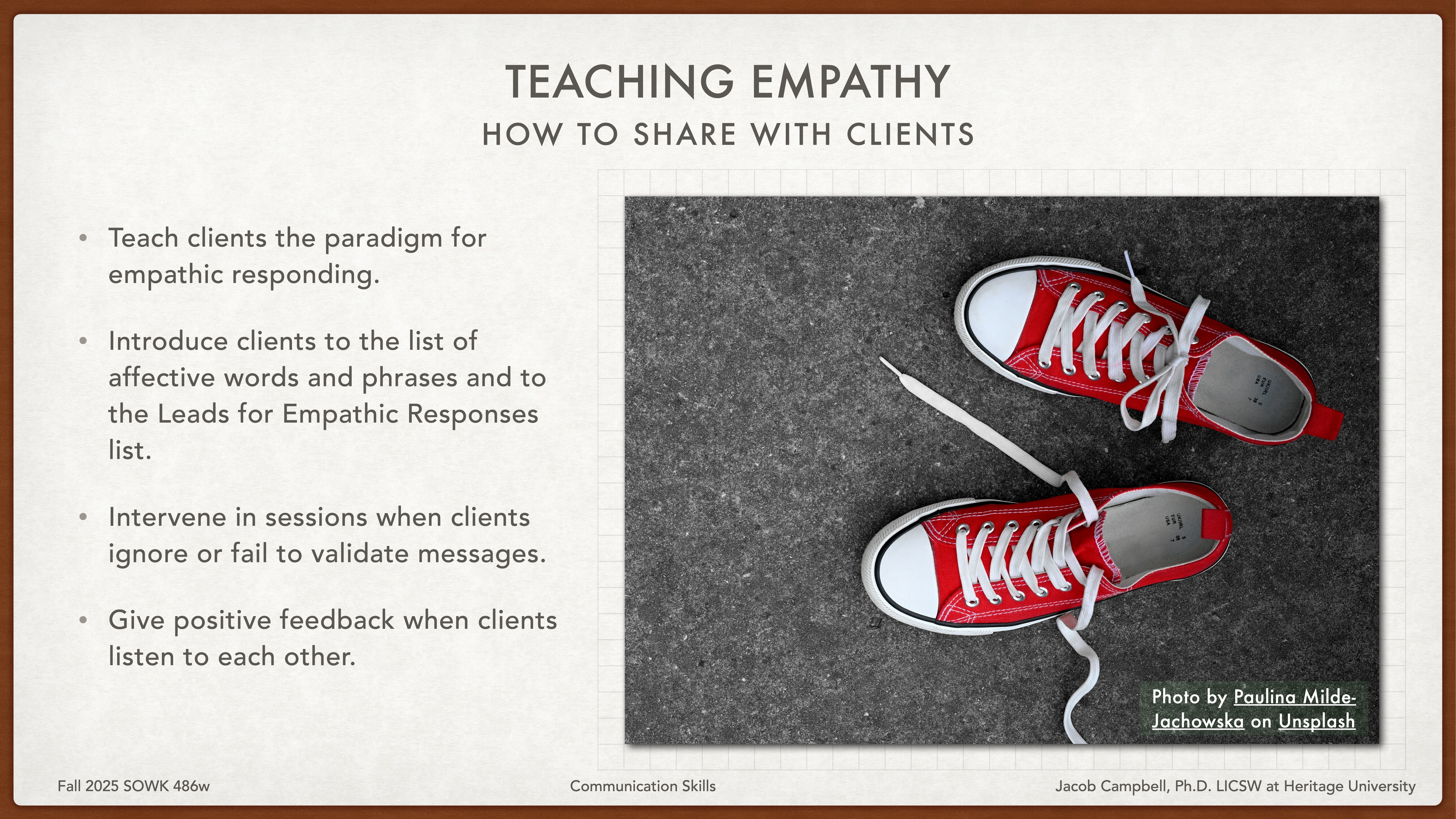 A pair of red sneakers is untied against a dark, textured background. Text on the slide titled 'Teaching Empathy' discusses teaching clients empathetic responding, such as validation and providing positive feedback.
