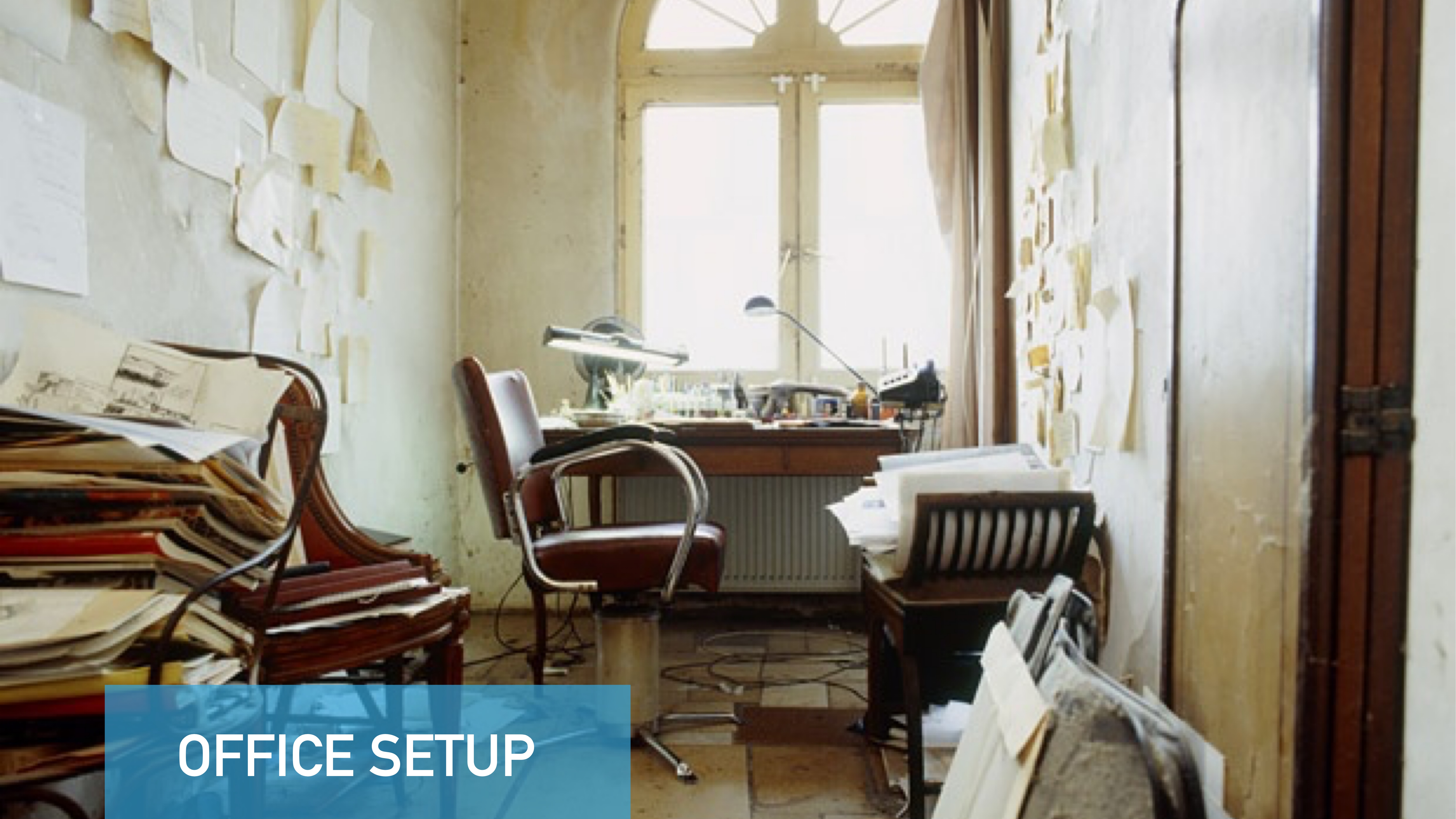 Office chair faces cluttered desk; drafts and papers scattered around. Room filled with light from large window. Text reads 'OFFICE SETUP.' Walls have papers and notes attached.